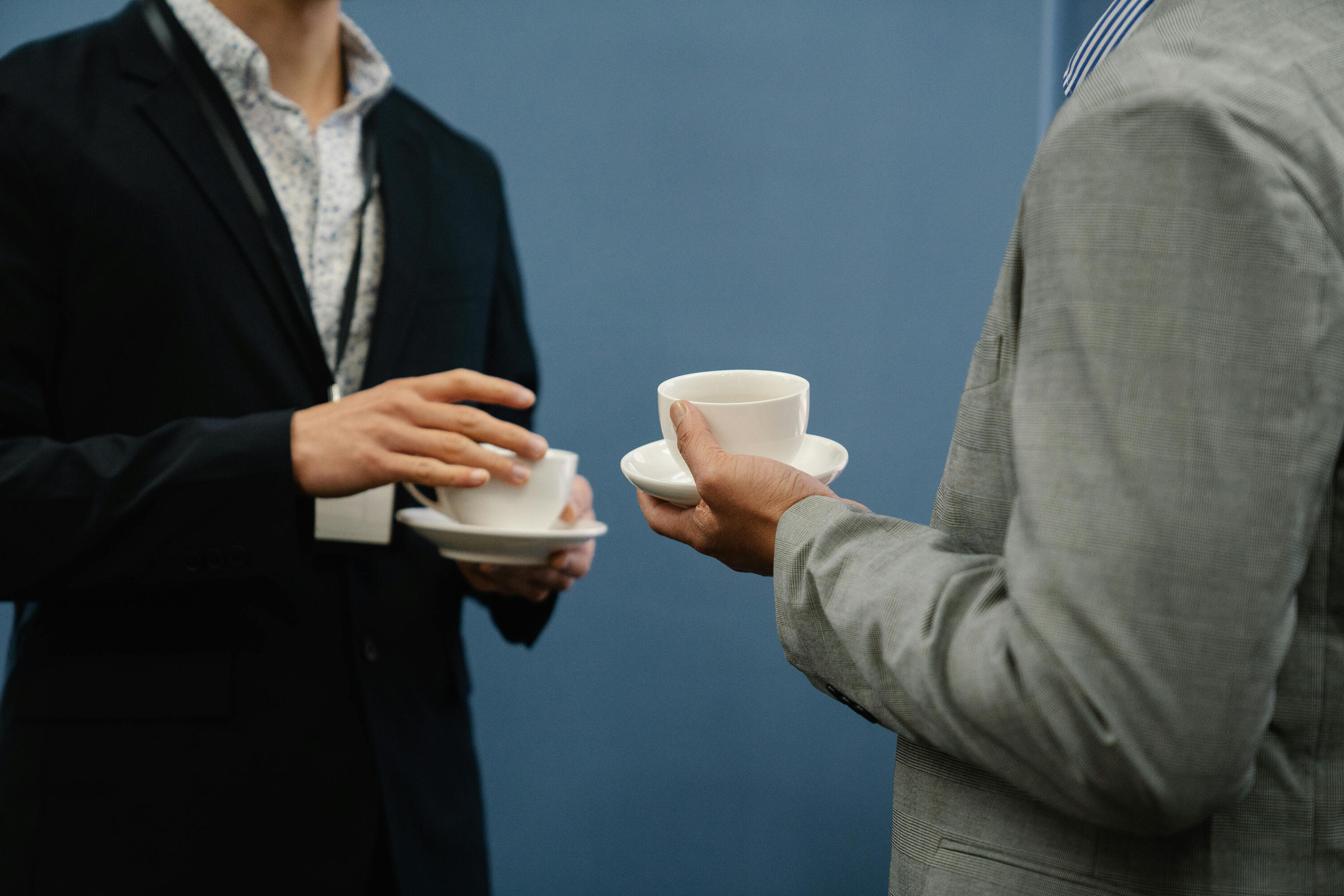 Felicity Tai "Two business professionals holding coffee cups during a casual meeting or event." by Felicity Tai.